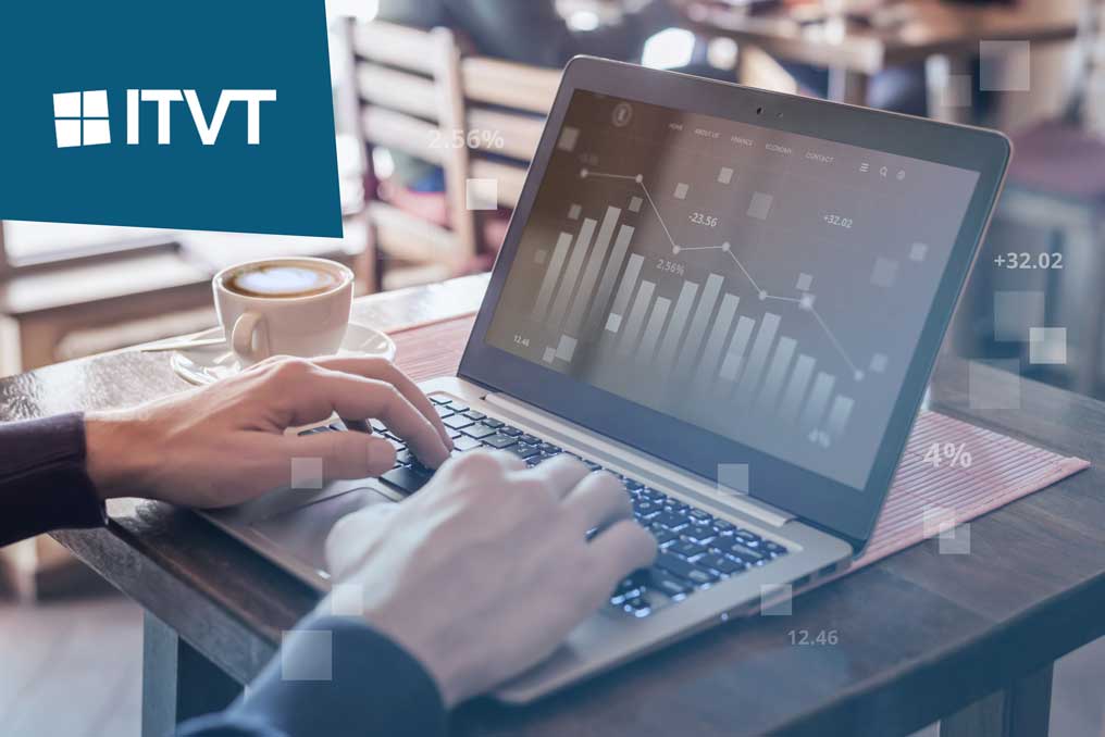 Person, die auf einem Laptop tippt, auf dem Balkendiagramme und Datenanalysen angezeigt werden, mit ITVT-Logo in der oberen linken Ecke und einer Kaffeetasse auf dem Tisch