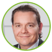 Ein professionelles Business-PortrÃ¤t in einem runden grÃ¼nen Rahmen, das eine Person in formeller GeschÃ¤ftskleidung vor einem klaren, hellen Hintergrund zeigt und damit unternehmerische ProfessionalitÃ¤t sowie ein gepflegtes FÃ¼hrungsprofil vermittelt.