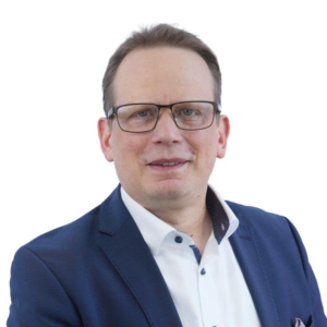 Ein professionelles PortrÃ¤t einer Person, die eine marineblaue Anzugjacke und ein weiÃŸes Hemd trÃ¤gt, fotografiert vor einem sauberen weiÃŸen Hintergrund. Das Bild wurde fÃ¼r das Corporate Branding und die Materialien von ITVT erstellt.